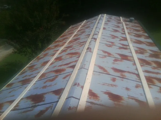 Rusted metal roof panels with new wood purlins before replacement — Storm Damage Roof Repair in Windfall by Roofing Brothers