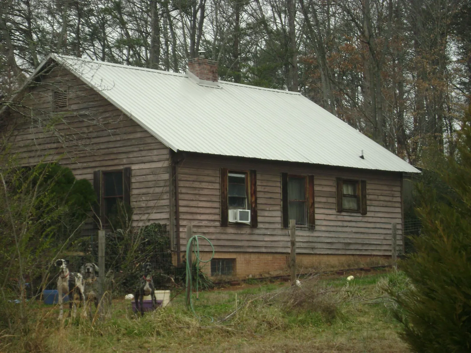 White metal roof on an old wood sided farmhouse, from a Metal Roof Installation job in Windfall